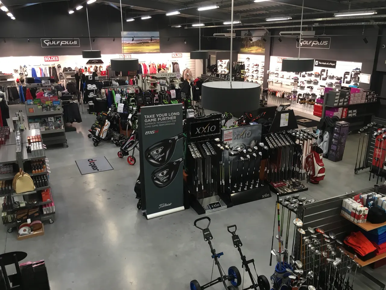 Intérieur du magasin Golf Plus avec rayonnages et présentoirs